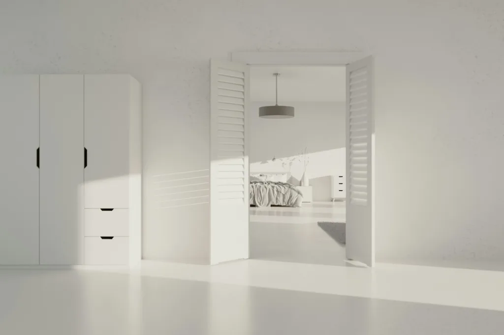 Bright minimalist bedroom with white wardrobe, open shutters, and a bed visible through the doorway